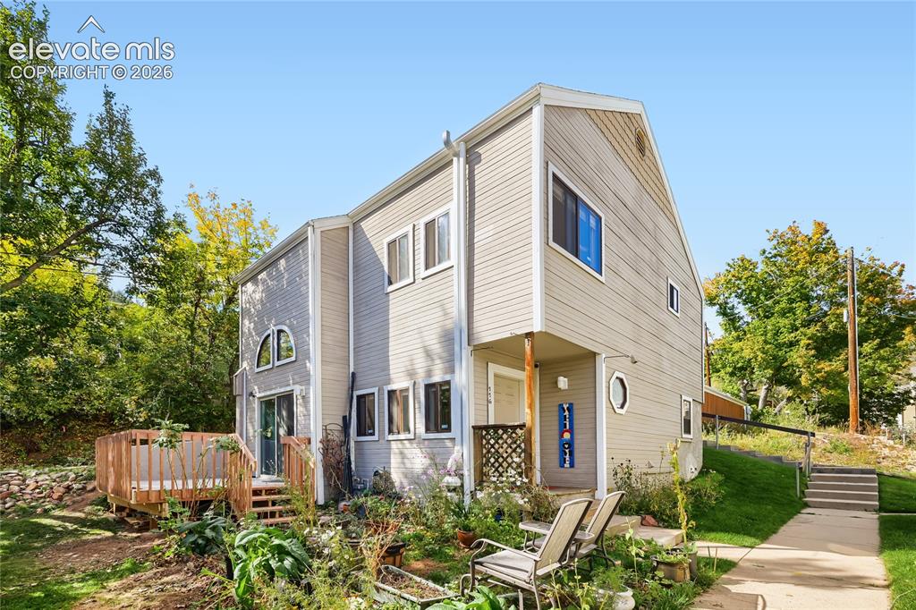 Caption: Modern two-story residence featuring cream-colored fiber cement siding, multi-pane windows with blue