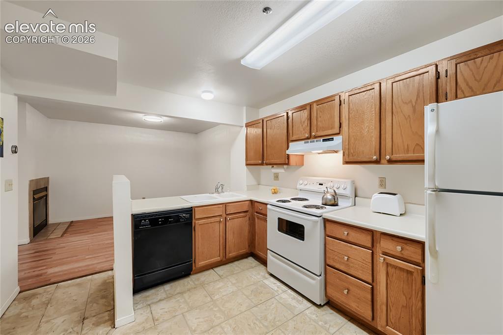 Image 12 of 37: Kitchen featuring wood cabinetry, white countertops, a white electric range