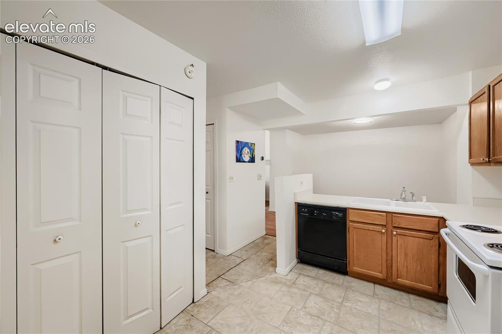 Image 13 of 37: Bright kitchen featuring white six-panel cabinetry, wood-finish upper cabin