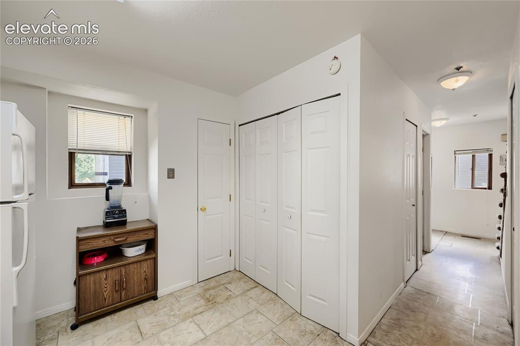 Image 14 of 37: Tile flooring, white paneled bifold doors, white paneled door, and a single