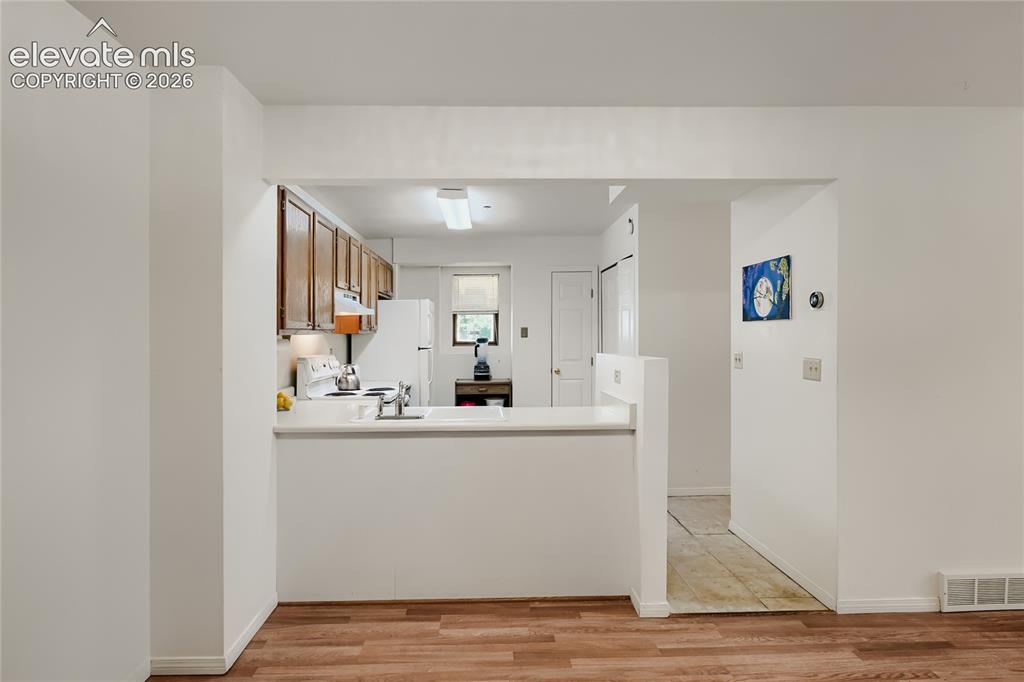 Image 15 of 37: Kitchen with wood-finish cabinetry, white countertops, a stainless steel si