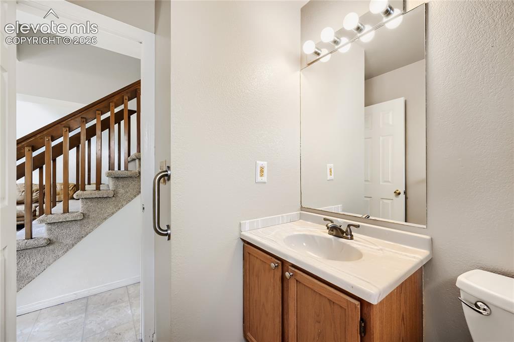 Image 26 of 37: Bright bathroom featuring a wood-finish vanity with ample countertop space,