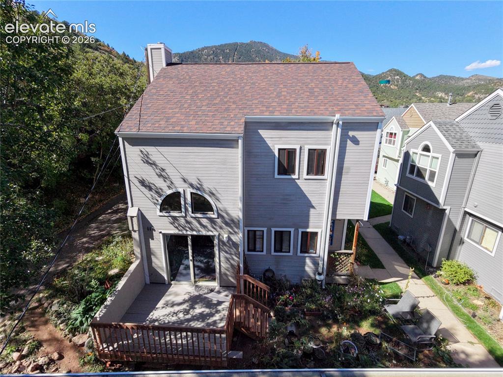 Image 33 of 37: Multi-level exterior with siding, a shingle roof, rear deck, and a patio ar
