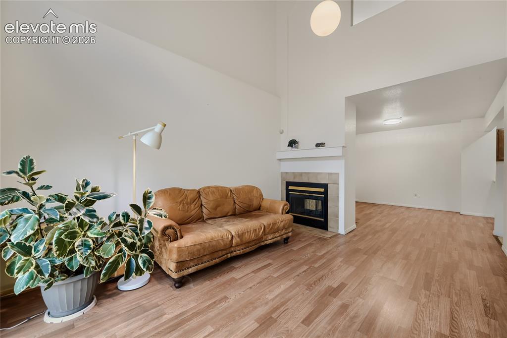 Image 4 of 37: Vaulted ceiling, wood-finish flooring, fireplace with tile surround, built-