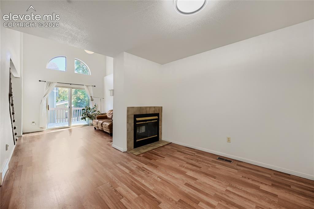 Image 8 of 37: Wood-finish flooring, high ceilings, arched transom windows, and a tiled fi