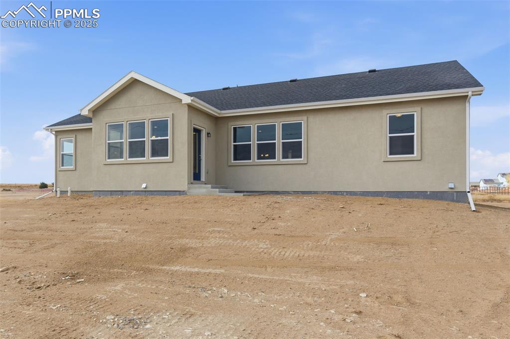 Image 28 of 30: Ranch-style home with stucco siding and roof with shingles