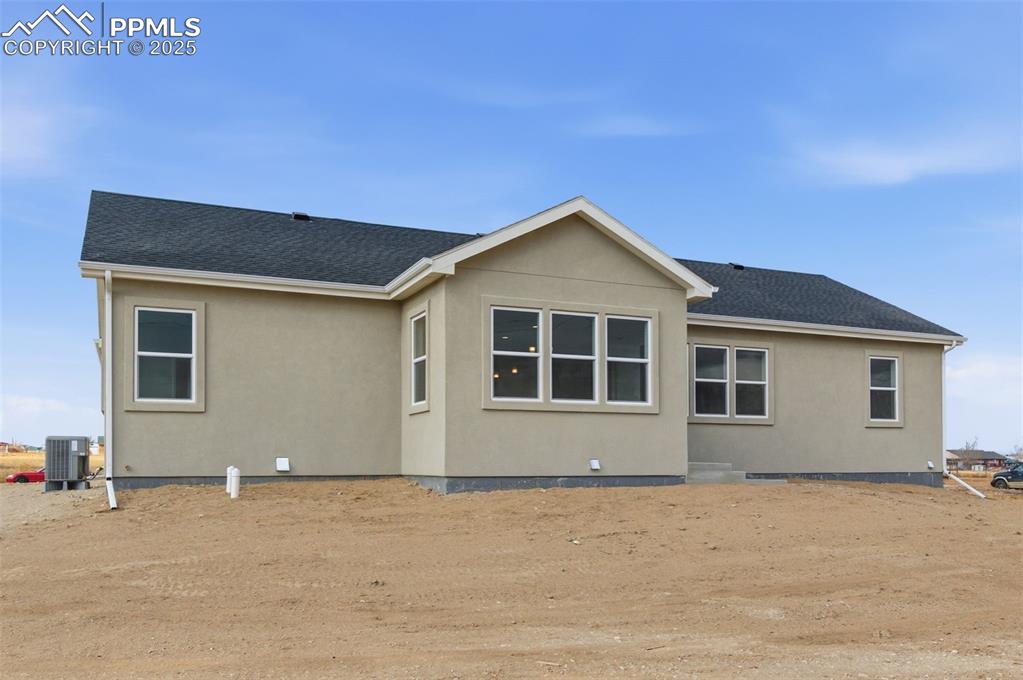 Image 30 of 30: Rear view of house with a shingled roof and stucco siding