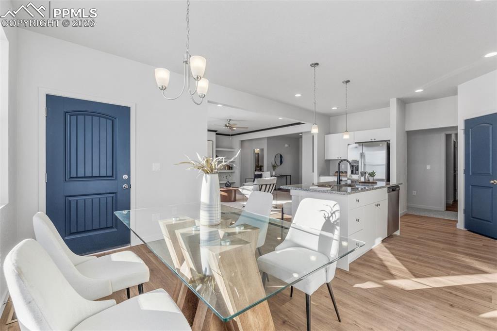 Image 31 of 46: Dining area featuring a ceiling fan, light wood-type flooring, a chandelier