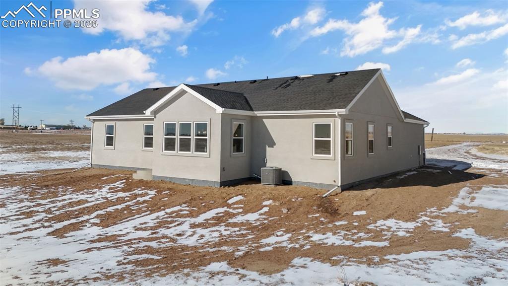 Image 39 of 46: Snow covered property featuring stucco siding and a shingled roof