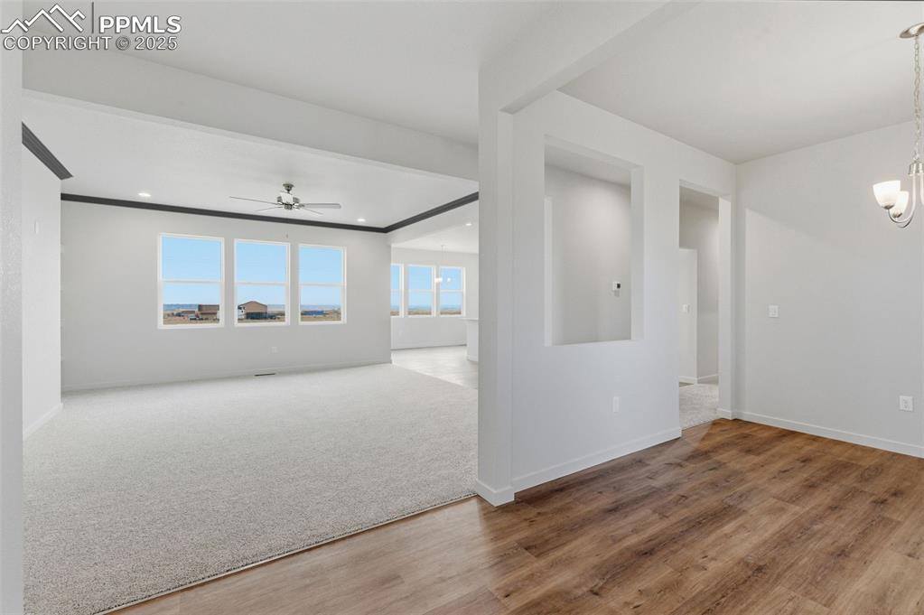 Image 4 of 30: Spare room with a chandelier, wood finished floors, ceiling fan, and recess