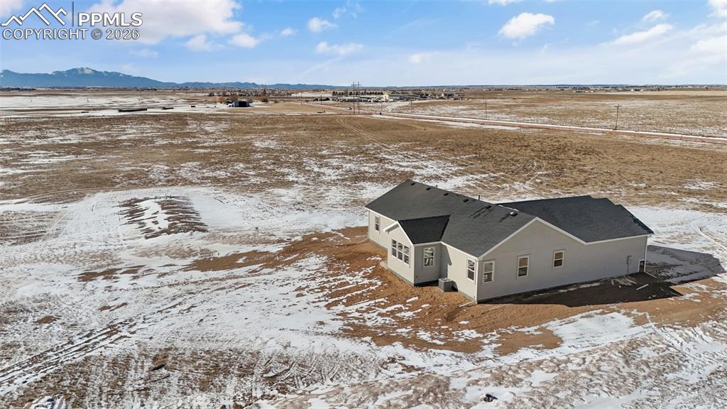 Image 43 of 46: Snowy aerial view featuring a mountain view and a view of countryside