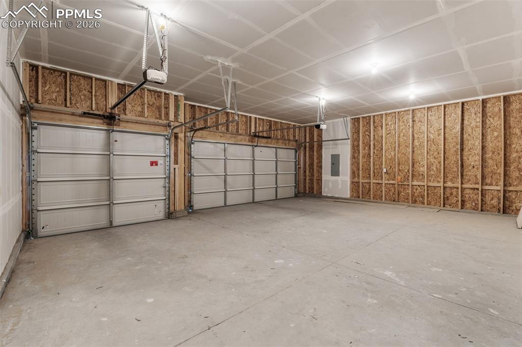 Image 46 of 46: Garage featuring electric panel and a garage door opener