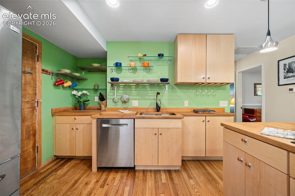 Image 10 of 48: Kitchen featuring wood-finish flooring, light wood cabinetry, wood countert