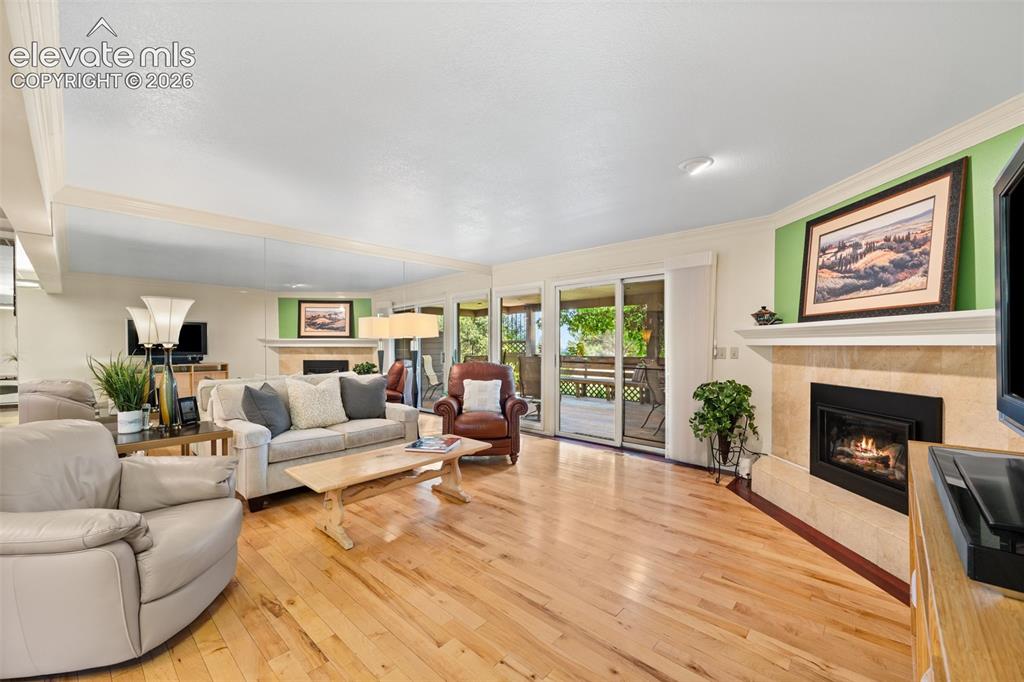 Image 16 of 48: Spacious living area featuring wood-finish flooring, a tiled fireplace with