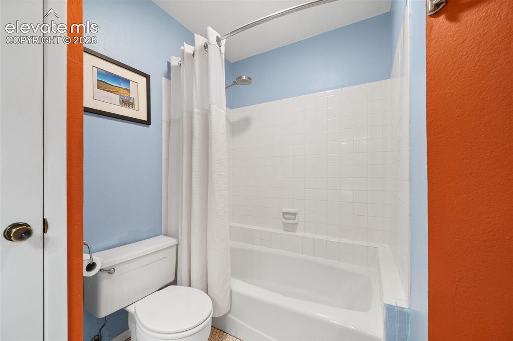 Image 20 of 48: Bathroom featuring a white bathtub, white subway tile surround, and a chrom