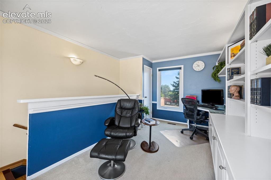 Image 25 of 48: Dedicated workspace featuring built-in white shelving, a window with exteri