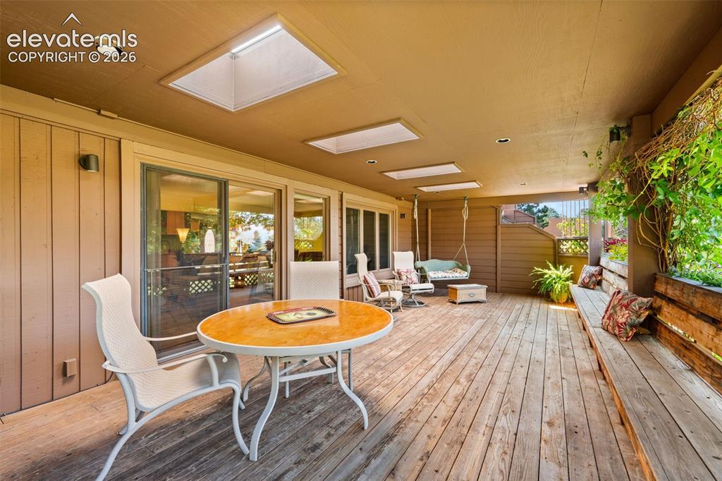 Image 34 of 48: Covered exterior deck with wood flooring and skylights