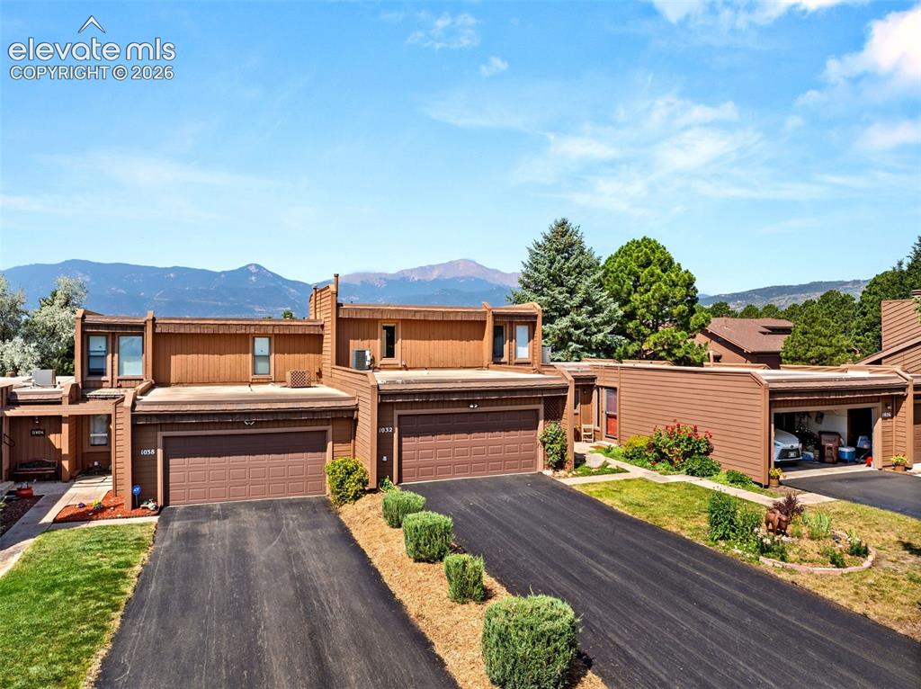 Image 40 of 48: Townhome exterior featuring mountain scenery, brown siding, attached garage