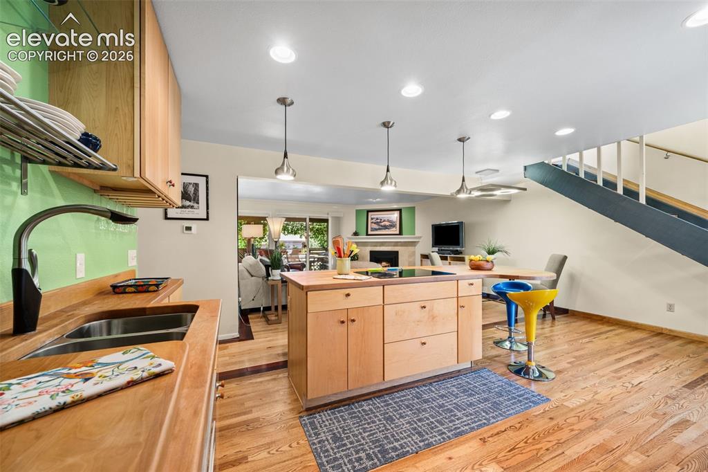 Image 9 of 48: Modern kitchen featuring warm wood cabinetry, stainless steel double basin