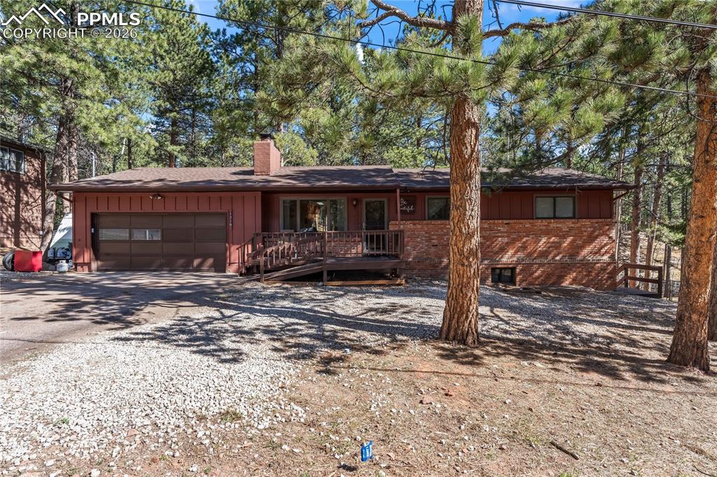 Image 1 of 47: Exterior featuring a two-car garage, brick facade, wood siding, front deck 