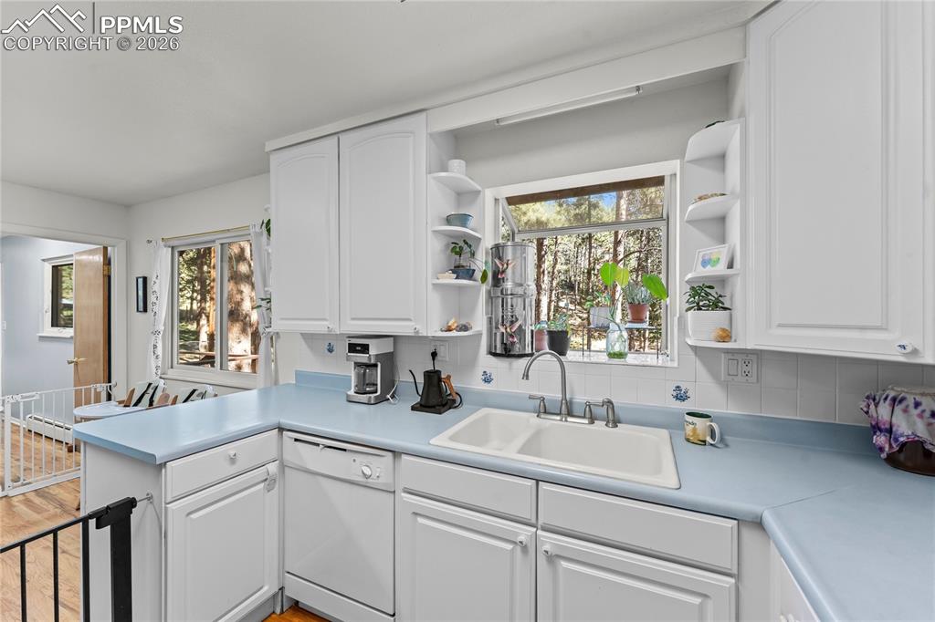 Image 13 of 47: Kitchen featuring white cabinetry and light blue countertops
