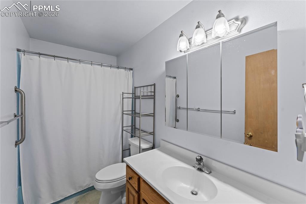 Image 16 of 47: Bathroom featuring a vanity with wood cabinetry, a white countertop, and an