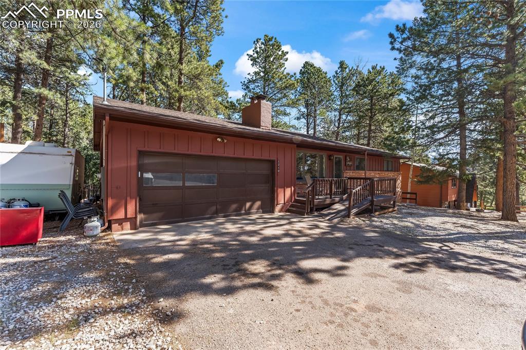 Image 2 of 47: Wood-sided exterior with a prominent brown garage door and an expansive gra