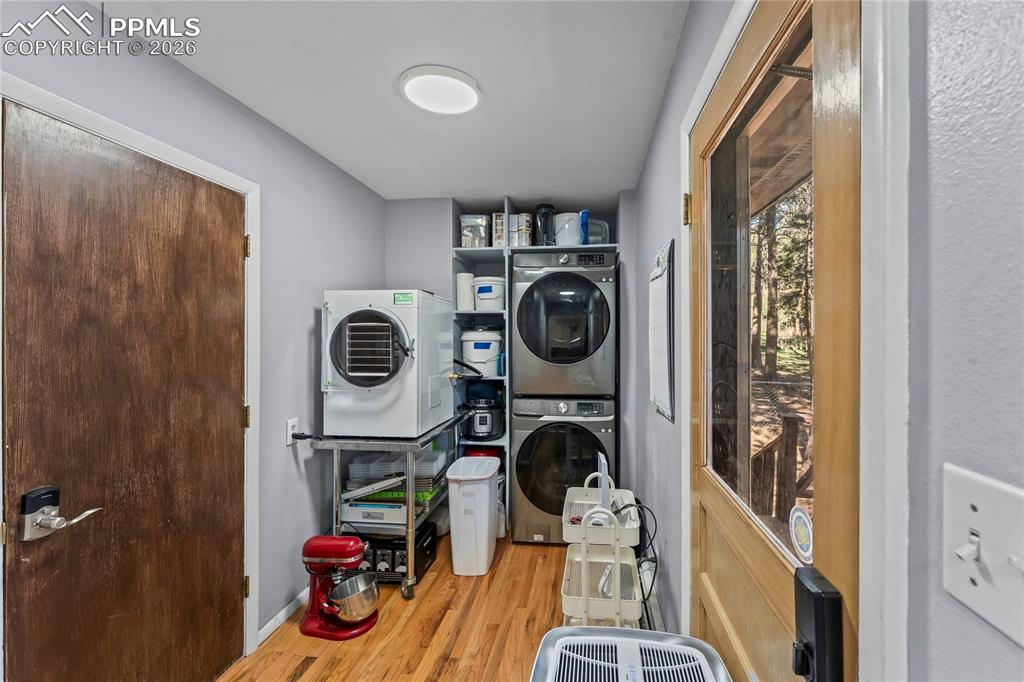 Image 25 of 47: Dedicated utility area featuring wood-finish flooring and a built-in shelvi