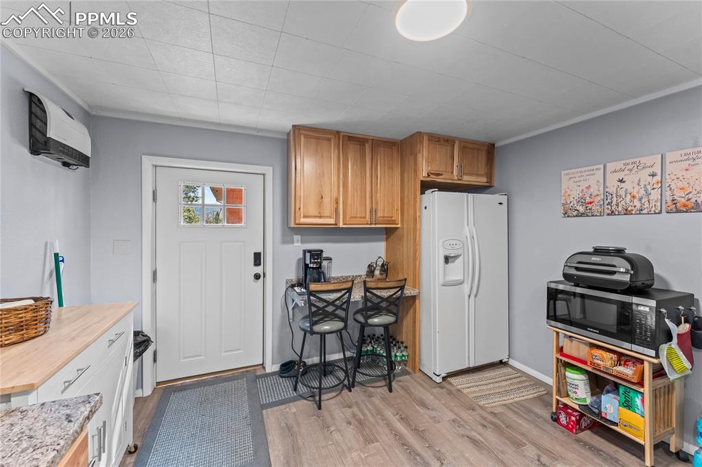 Image 27 of 47: Basement entrance and kitchen area featuring wood-finish flooring, light bl