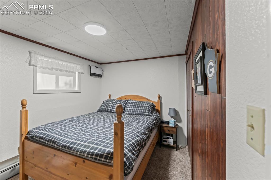 Image 31 of 47: Interior room featuring a wood-panel accent wall with built-in sliding clos