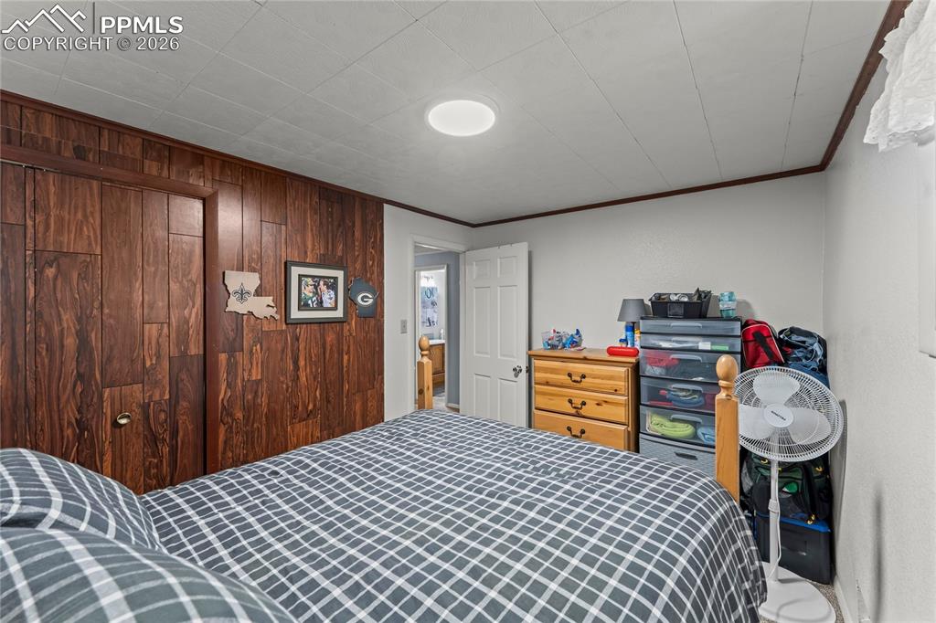 Image 32 of 47: Bedroom featuring wood-finish wall paneling, a flush-mount ceiling light, a