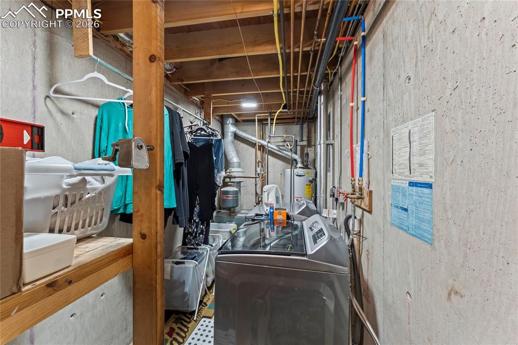 Image 39 of 47: Utility space and second washer and dryer featuring exposed concrete walls 