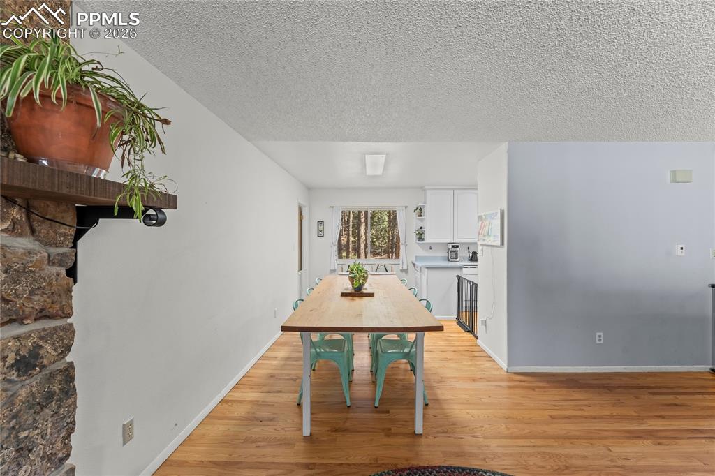 Image 7 of 47: Open-concept living space featuring wood-finish flooring, a stone accent wa