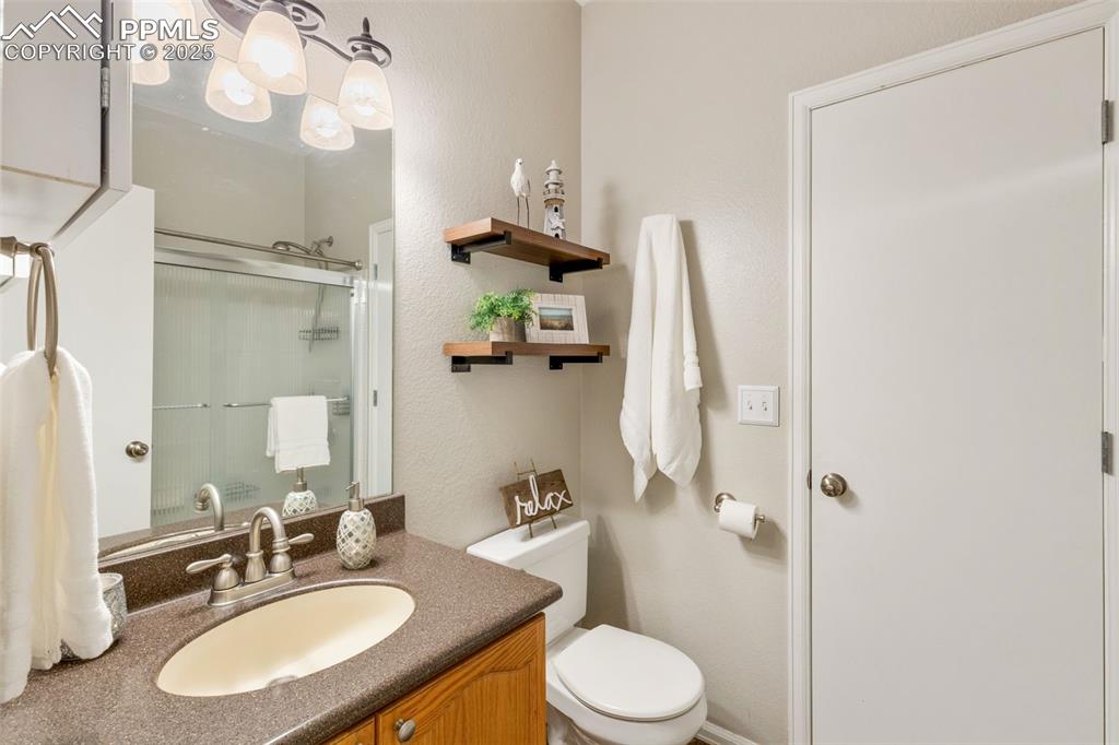 Image 25 of 35: Bathroom featuring a shower with door and vanity