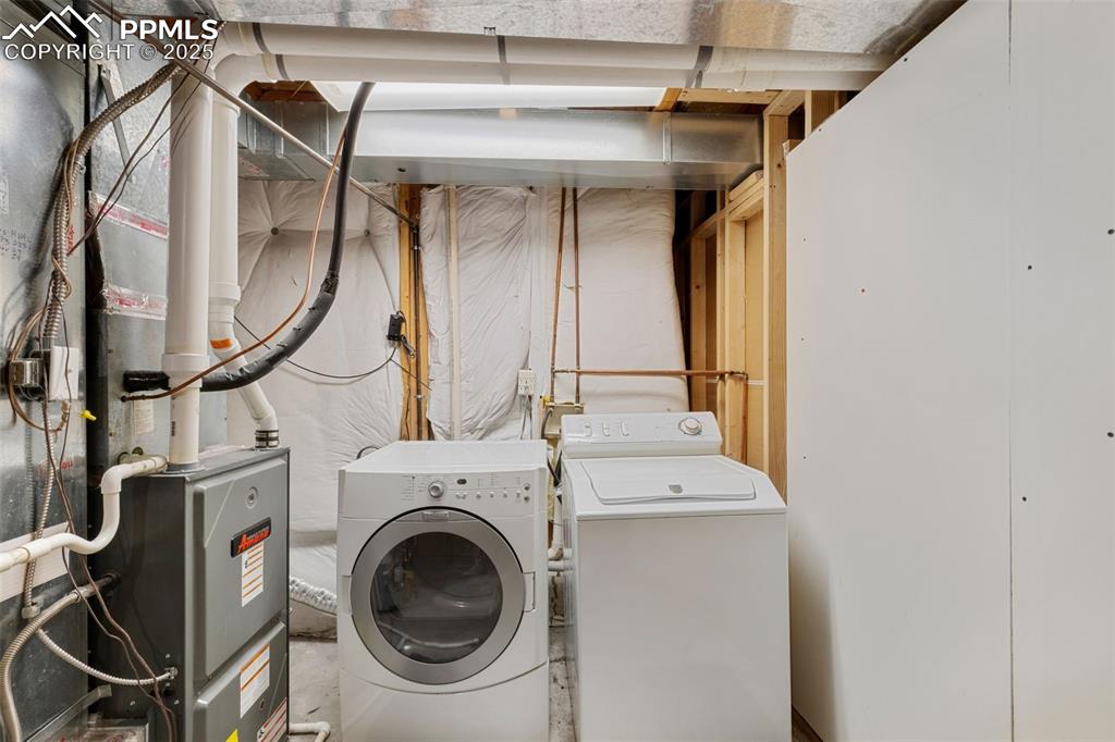 Image 32 of 35: Washroom featuring washer and clothes dryer and heating unit