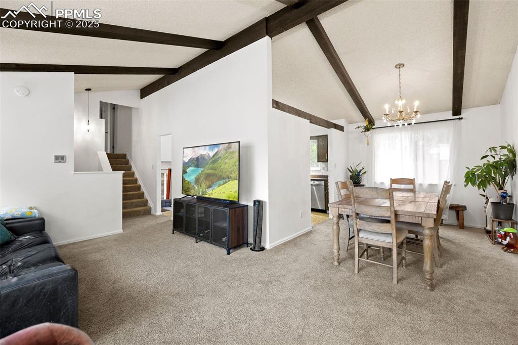 Image 11 of 50: Carpeted dining area featuring a chandelier and a textured ceiling