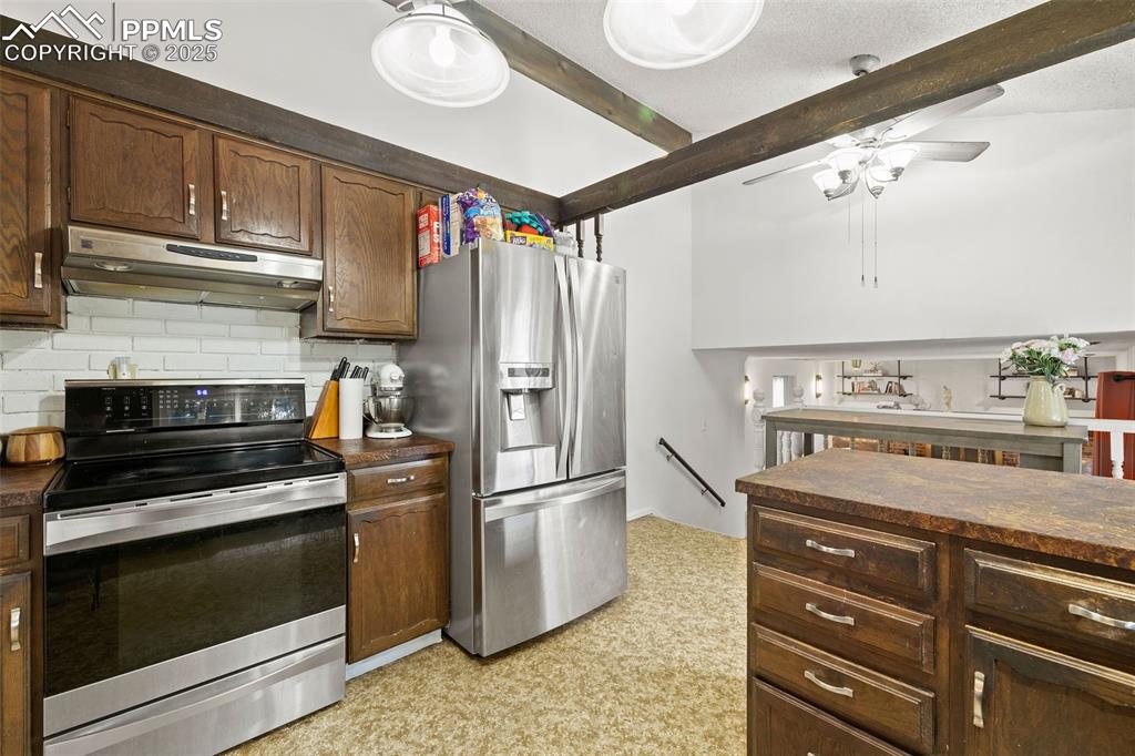 Image 15 of 50: Kitchen featuring appliances with stainless steel finishes, under cabinet r