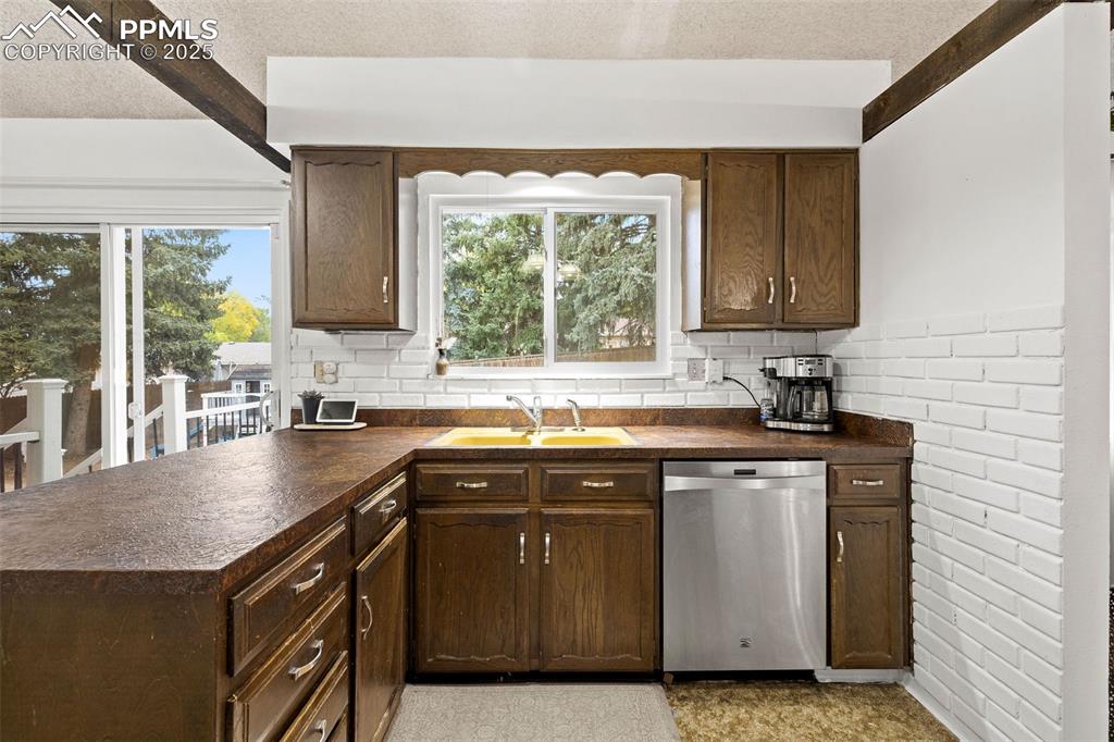 Image 18 of 50: Kitchen featuring dark countertops, a textured ceiling, a peninsula, stainl