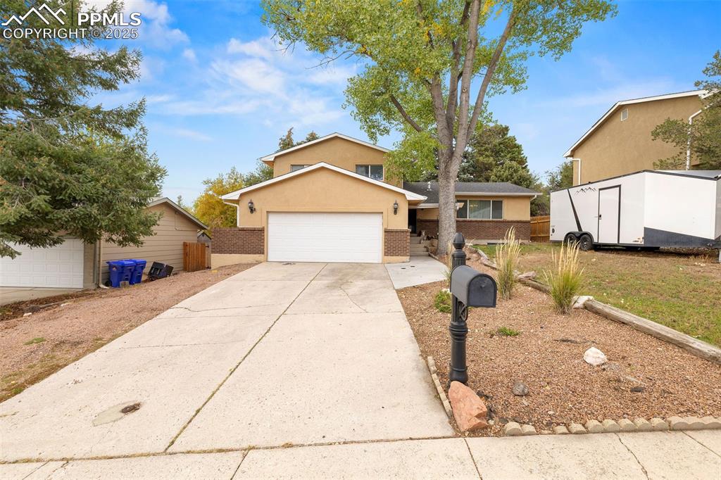 Image 2 of 50: View of front facade featuring concrete driveway, stucco siding, an attache