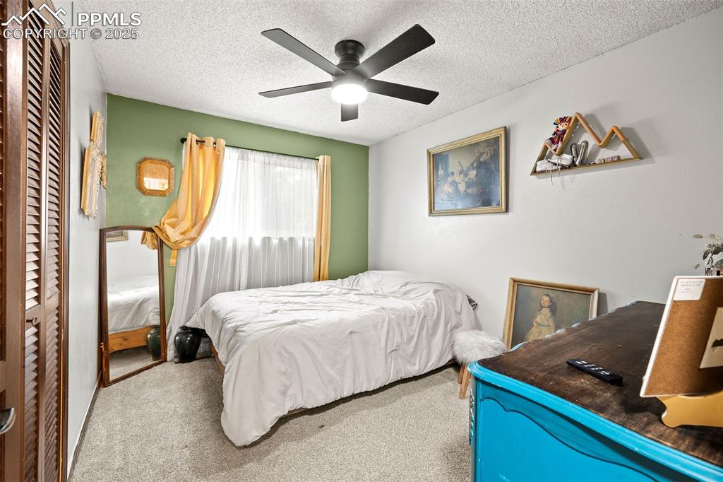 Image 21 of 50: Bedroom featuring carpet, a textured ceiling, a closet, and ceiling fan
