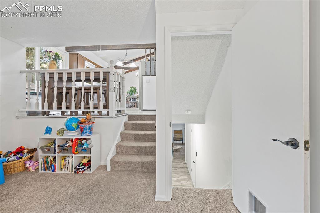 Image 34 of 50: Stairway with carpet flooring and a textured ceiling