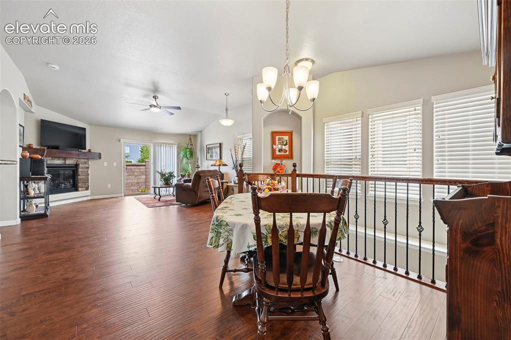 Image 17 of 38: Open-concept living space featuring wood-finish flooring, a stone fireplace