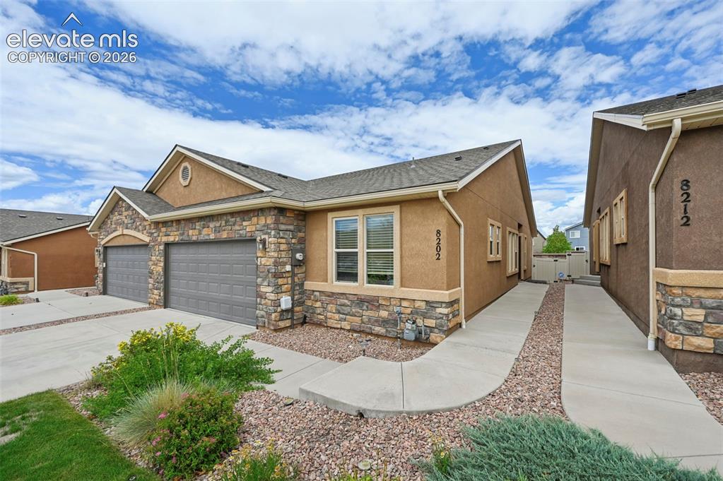 Image 2 of 38: Exterior featuring stone accents, stucco siding, and a two-car garage