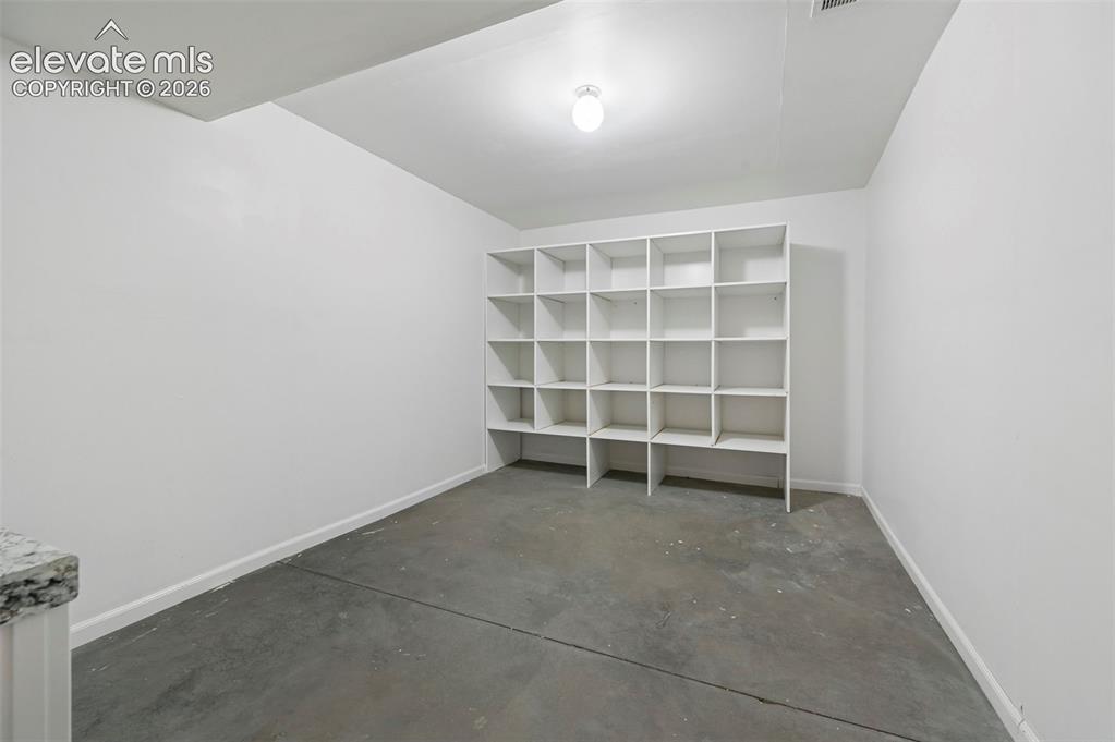 Image 34 of 38: Basement storage room with built-in shelving