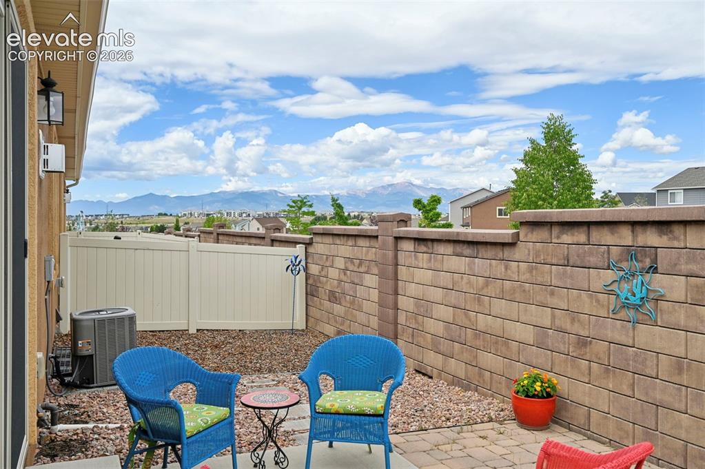 Image 36 of 38: Outdoor patio featuring paver stones and a stone block privacy wall - look