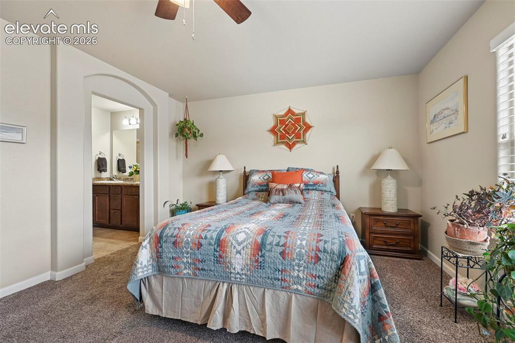 Image 6 of 38: Carpeted room featuring an arched doorway leading to an adjoining bathroom