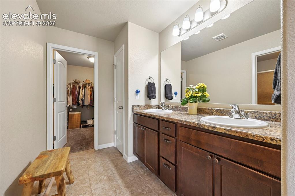 Image 9 of 38: Primary Bathroom featuring a dual vanity with a patterned countertop and wo
