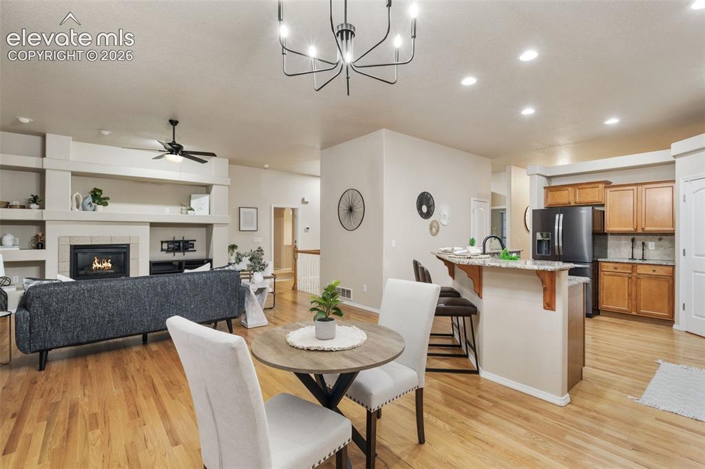 Image 14 of 50: Hardwood flooring, kitchen island with bar seating, integrated fireplace, r