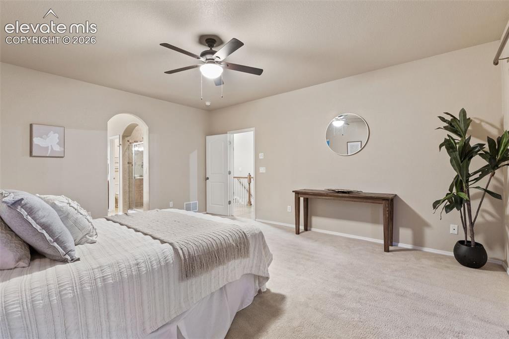 Image 18 of 50: Arched doorway entrance, ceiling fan with integrated lighting, neutral-tone