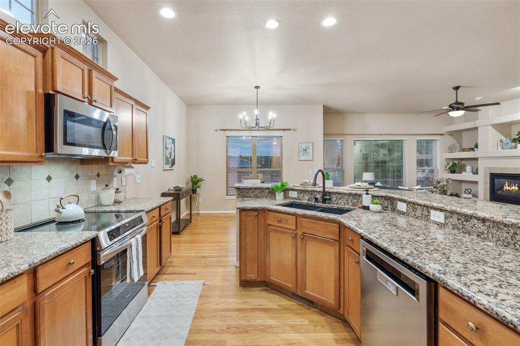 Image 2 of 50: Hardwood flooring, stainless steel appliances, speckled stone countertops, 